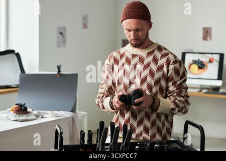 Man Adjusting Camera Settings in Professional Studio Stock Photo