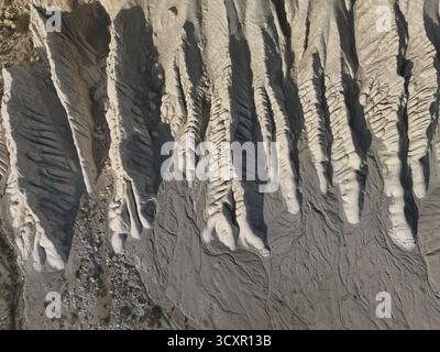 Earth's surface sculptured by wind and water, forming unique badlands geological formations displaying natural texture and abstract patterns from abov Stock Photo