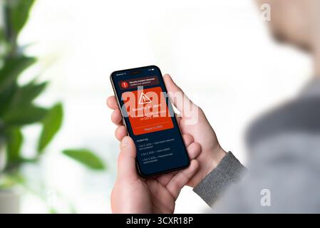 Smartphone displaying red GDPR security alert about data breach with report link to DPO, representing data incident notification and transparency Stock Photo