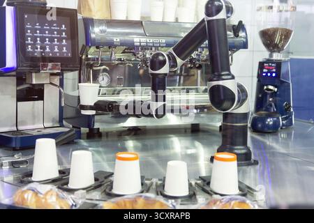 Robot with artificial intelligence making coffee on coffee machine. Food and drink Stock Photo