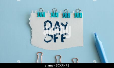 Day off text - workplace message in the office. Concept of absence from work and day off. Text DAY OFF on sticky notes bellow Calendar. Notification o Stock Photo