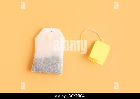 Tea bag with yellow label on orange background Stock Photo