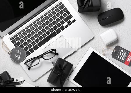 Gadgets with gifts on white grunge background. Cyber Monday Stock Photo