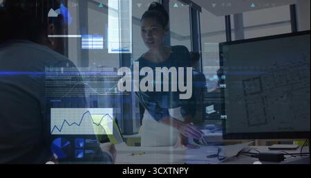 Leaning female manager discussing project in office, with laptop, blueprints and data overlays Stock Photo