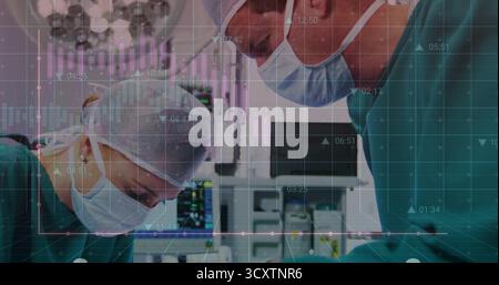 Surgeons operating under overhead lights in OR, with vital-sign monitors and data overlay Stock Photo