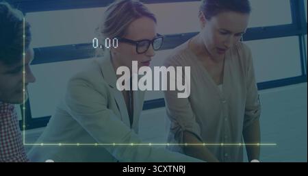 Collaborating colleagues studying documents in meeting room with notebook laptop digital line graph Stock Photo