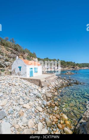 Vertical shot of a rustic white fisherman's hut (barraca) on the rocky shore of Cala Pallerida, an idyllic cove near Palamos, Costa Brava, Spain Stock Photo