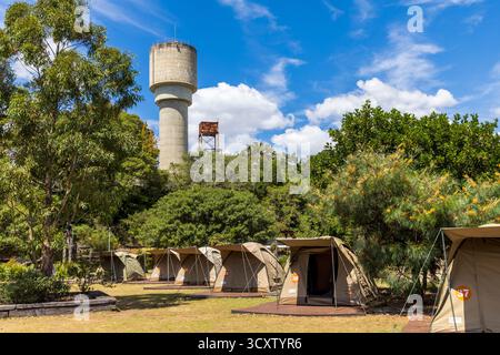 Tents on a campsite in front of Cockatoo Island power station water tower, Sydney, Australia Stock Photo