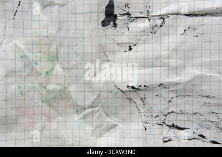 Old grid paper was torn and stained with black ink Stock Photo
