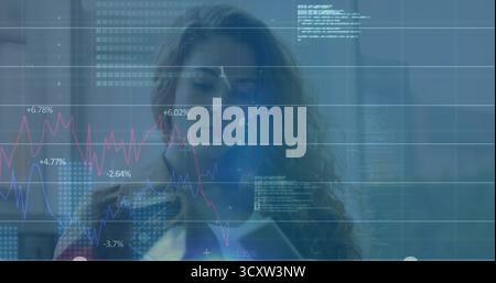 Analyzing woman wearing business attire reviewing numbers on tablet at office with percent charts Stock Photo