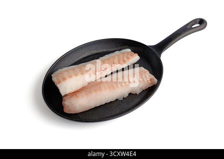 Two pieces of fish fillet on a black cast iron frying pan isolated on white background Stock Photo