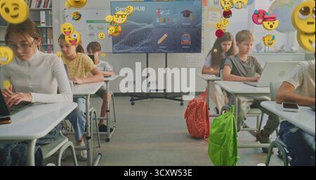 Schoolchildren in Modern Classrooms Learn Using Laptops. Emotional State of Kids Conveyed by Floating Emojis. Concept Digital Education, Online Communication, Emotions, Virtual Reality. Dolly Shot. Stock Photo