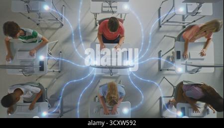 Group of Schoolchildren Intensely Working on Desktop Computers, Linked by Glowing Digital Connections. Kids Engagement in Collaborative Tech Network, Digital Literacy and Future ready Skills. Stock Photo