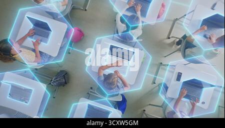 Children Sit at Desks Using Laptops, Surrounded by Luminous Digital Lines Symbolizing Virtual Connection and AI Collaboration. Technology Integration, and Future Focused Learning. Rotating Top View. Stock Photo