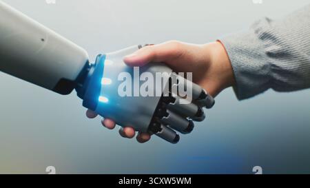 Close up of Human and Robotic Hand Shaking, Glowing With Digital Light. Human and Robot Handshake Symbolizing AI Collaboration. Concept of Connection Between People and AI in Future Technology. Stock Photo