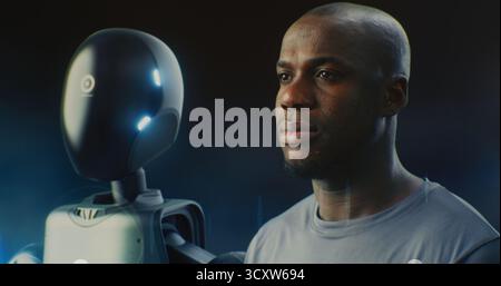 Close Up Focuses on African American Man Next Futuristic AI Robot, Both Appearing Calm and Reflective. Concept Technological Progress, and Integration of AI Into Everyday Life and Industry. Portrait. Stock Photo