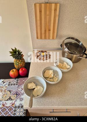A composition of pineapple, apples, and kitchen utensils waiting to be prepared or served on a bright, modern table. Stock Photo