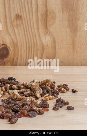 Autumn still life with raw almonds, black raisins, split walnuts, and goji berries on an aged oak board Stock Photo