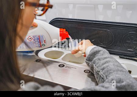 Client using the detergent in washing machine in self-service laundry. High quality photo Stock Photo