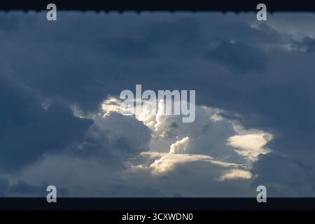 Dramatic storm clouds with sunlight breaking through Stock Photo