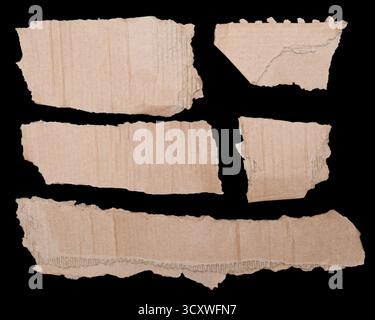Torn pieces of cardboard on black background Stock Photo