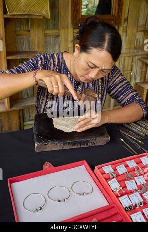 A Balinese craftswoman making silver jewelry in her workshop. Karangasem, Bali, Indonesia. Stock Photo