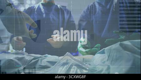 Performing surgical team conducting surgery on draped patient in operating room with HUD overlays Stock Photo