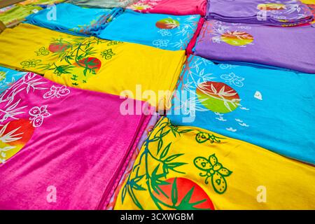 Colourful selection of bamboo fabric clothes folded and displayed in a gift shop. Kuta, Bali, Indonesia. Stock Photo
