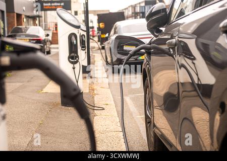 Electric cars on street charging with visible charging infrastructure Stock Photo