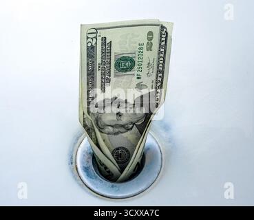 Money going down the drain being wasted and used poorly Stock Photo