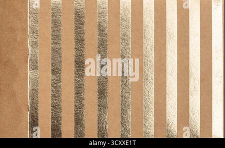 A series of shiny metallic foil stripes runs vertically across a textured brown surface, creating an eye-catching design perfect for artistic projects Stock Photo