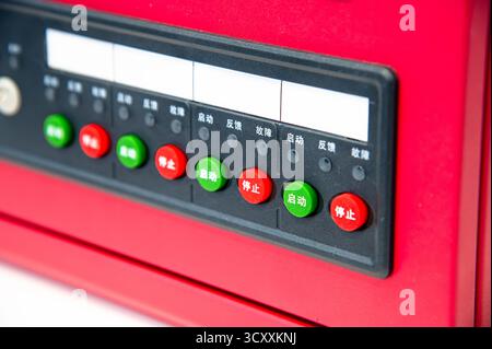 A red device with buttons in different colors and foreign writing. The device is likely a computer or a calculator Stock Photo
