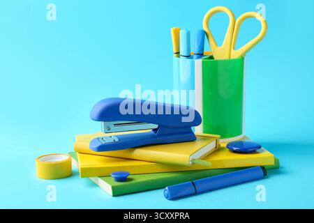 Stapler and other stationery on light blue background. Space for text Stock Photo