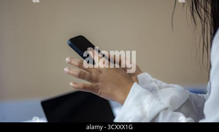 Close-up of woman using smartphone with finger touching screen, representing digital lifestyle, online communication, and modern mobile technology in Stock Photo