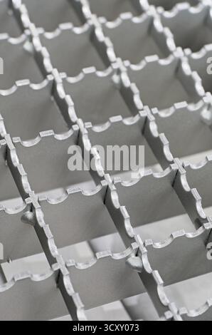 Openwork serrated metal lattice with square cells, close-up shot, abstract background Stock Photo