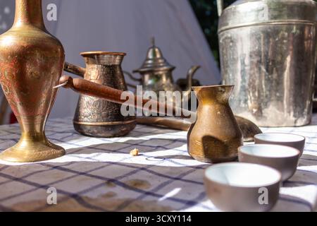 Ancient turkish coffee ceremony with traditional copper cezve and small cups on checkered tablecloth Stock Photo