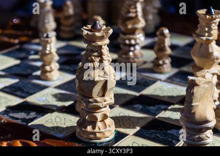 A beautiful wooden chess set with a queen in focus on a dark chessboard for strategic games and intellectual challenges Stock Photo