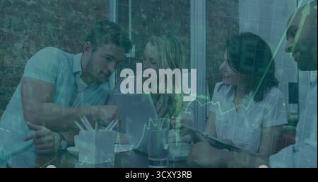 Collaborating professionals pointing and gesturing around laptop in office lounge, with tablet Stock Photo