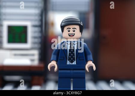 Tambov, Russian Federation - October 16, 2025 A happy Lego businessman minifigure standing in his office in front of a computer. Stock Photo