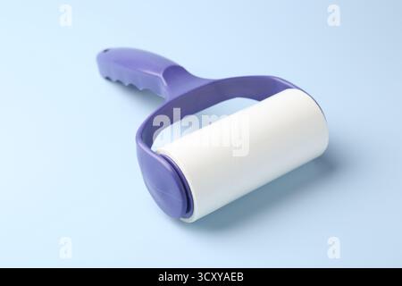 One lint roller on light blue background, closeup Stock Photo
