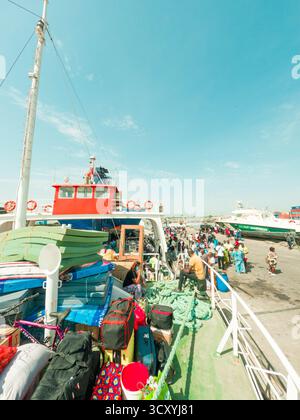 A crowded public ferry with local passengers departs for Bubaque Island in the Bijagos Archipelago, Guinea-Bissau Stock Photo