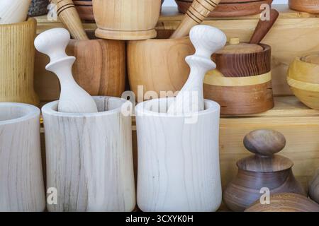 Collection of handmade wooden mortars and pestles arranged on display, highlighting natural wood tones, artisanal craftsmanship, and the rustic charm Stock Photo