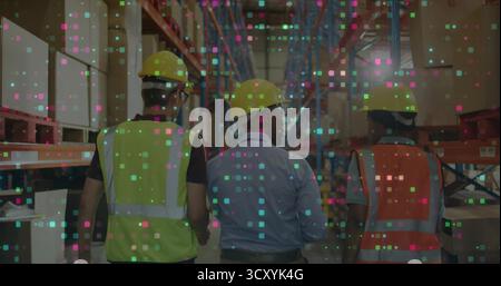 Walking warehouse workers wearing yellow safety helmets and vests down central aisle, grid overlay Stock Photo