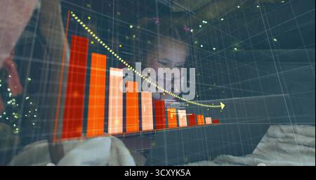 Reclining girl analyzing declining 3D chart arrow on laptop in bedroom, with string lights, blanket Stock Photo