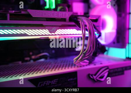 Colorful illumination of a graphics card in a custom gaming computer setup at night Stock Photo