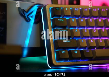 Colorful gaming keyboard with RGB lighting effects in a modern gaming setup at night Stock Photo