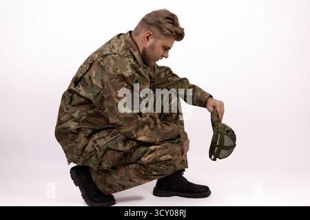 The soldier, weary from duty, kneels in a moment of solemn reflection Stock Photo