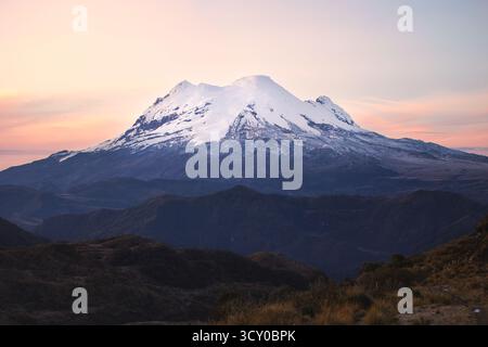Snow-covered Antisana Volcano at sunrise, viewed from the high Andes of Ecuador in Cayambe-Coca National Park Stock Photo