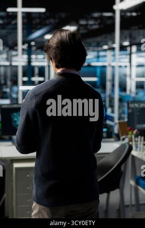 Data center system administrator deploying servers and doing maintenance on network hardware. IT professional in server room managing large scale IT infrastructure rackmounts Stock Photo