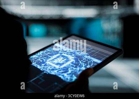 Close up of data center programmer using AI neural networks on tablet to troubleshoot backend operations. Server hub worker runs machine learning software development tools, resolving system crashes Stock Photo
